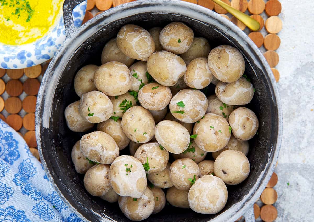 Syracuse Salt Potatoes in a black cast iron pot with butter in a bowl for dipping.