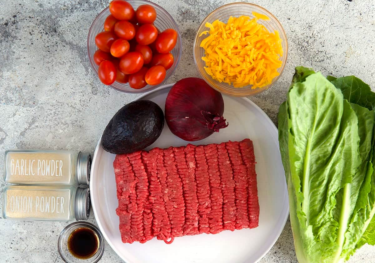 Burger Bowl Ingredients with ground beef, seasonings, tomato, lettuce, cheese