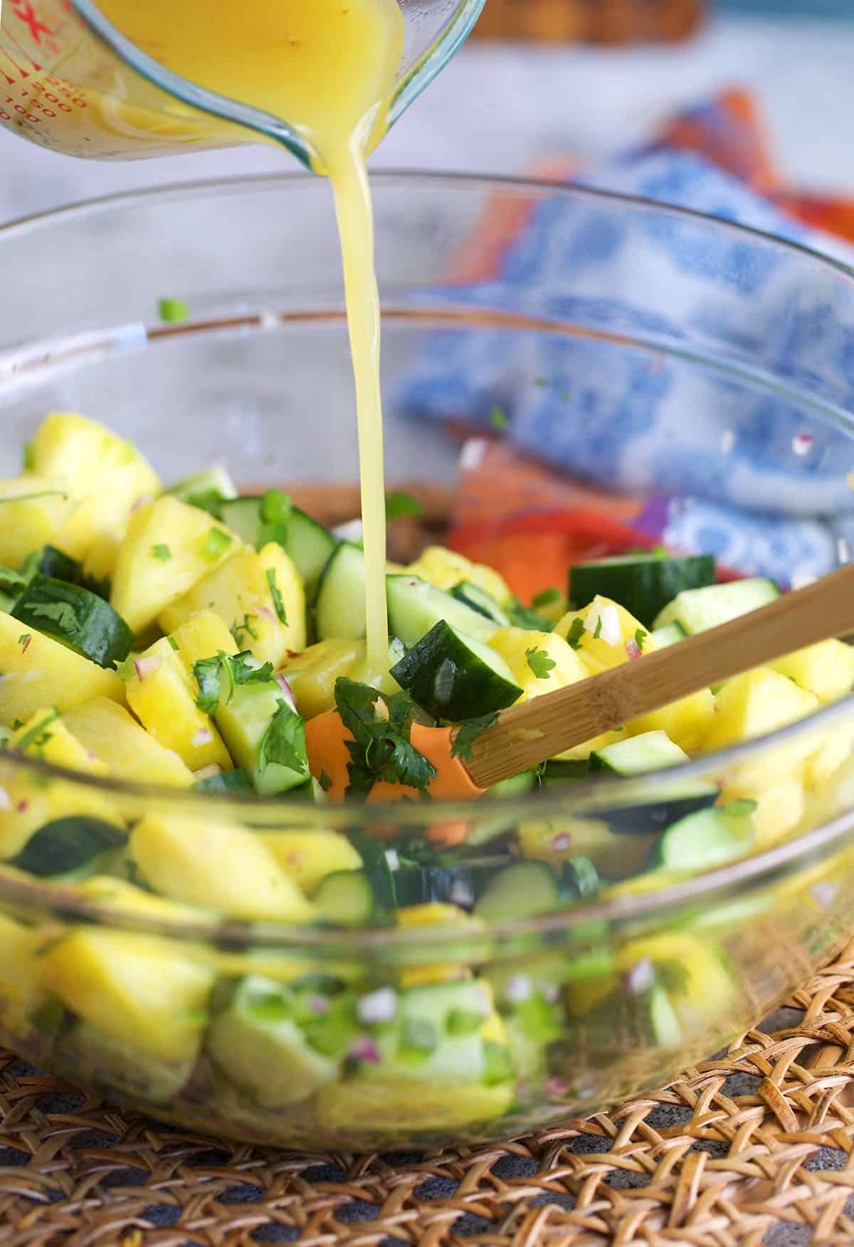 pineapple dressing being poured over a salad