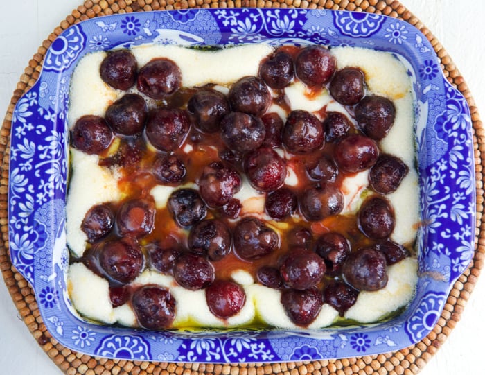 fresh cherries on top of cobbler batter ready to bake.