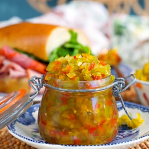 Pepper Relish in a small jam jar with a hero sandwich in the background.