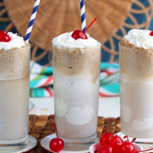 Root Beer Floats with a bowl of maraschino cherries in front of them.