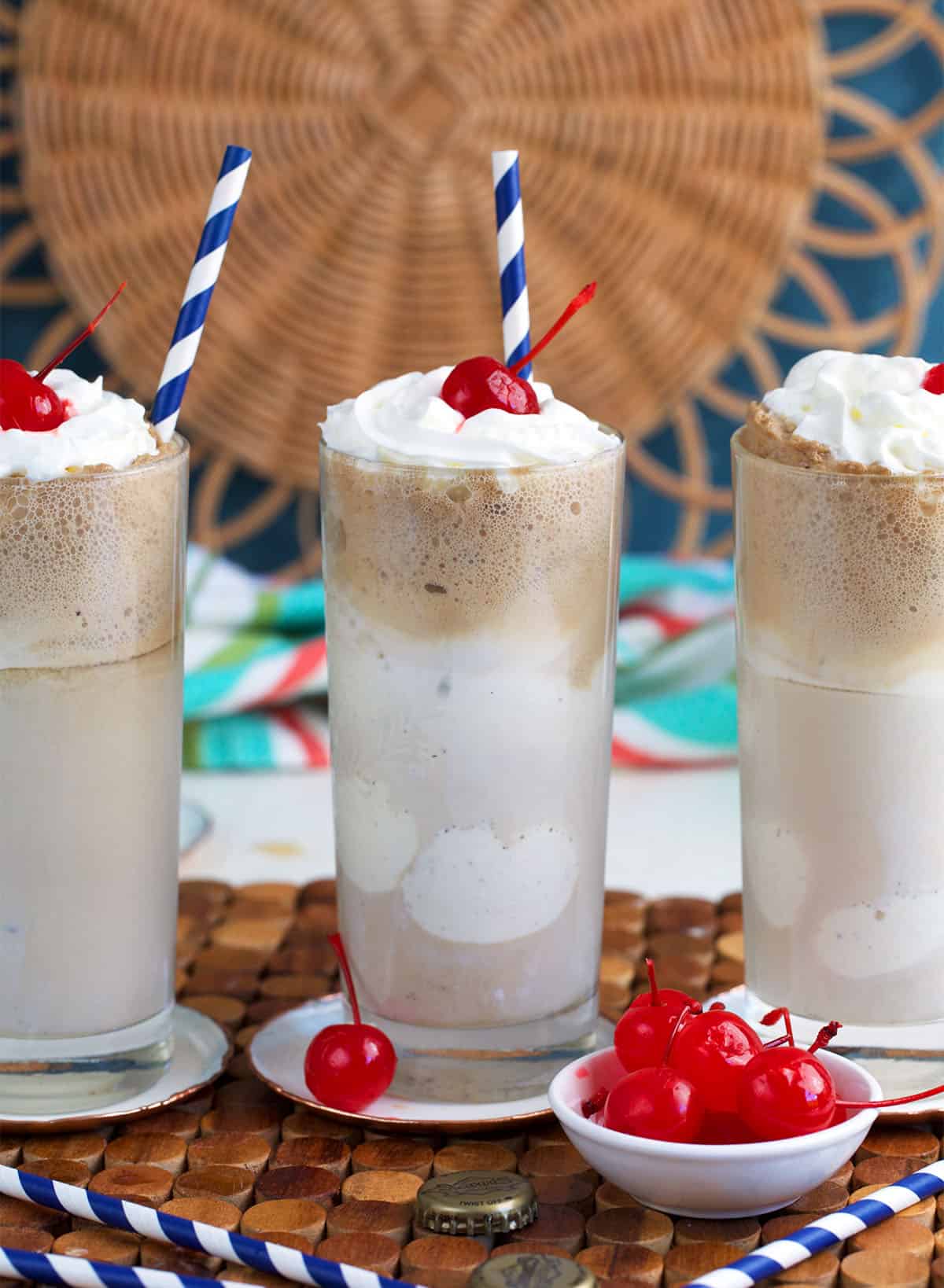 Root Beer Floats with a bowl of maraschino cherries in front of them.