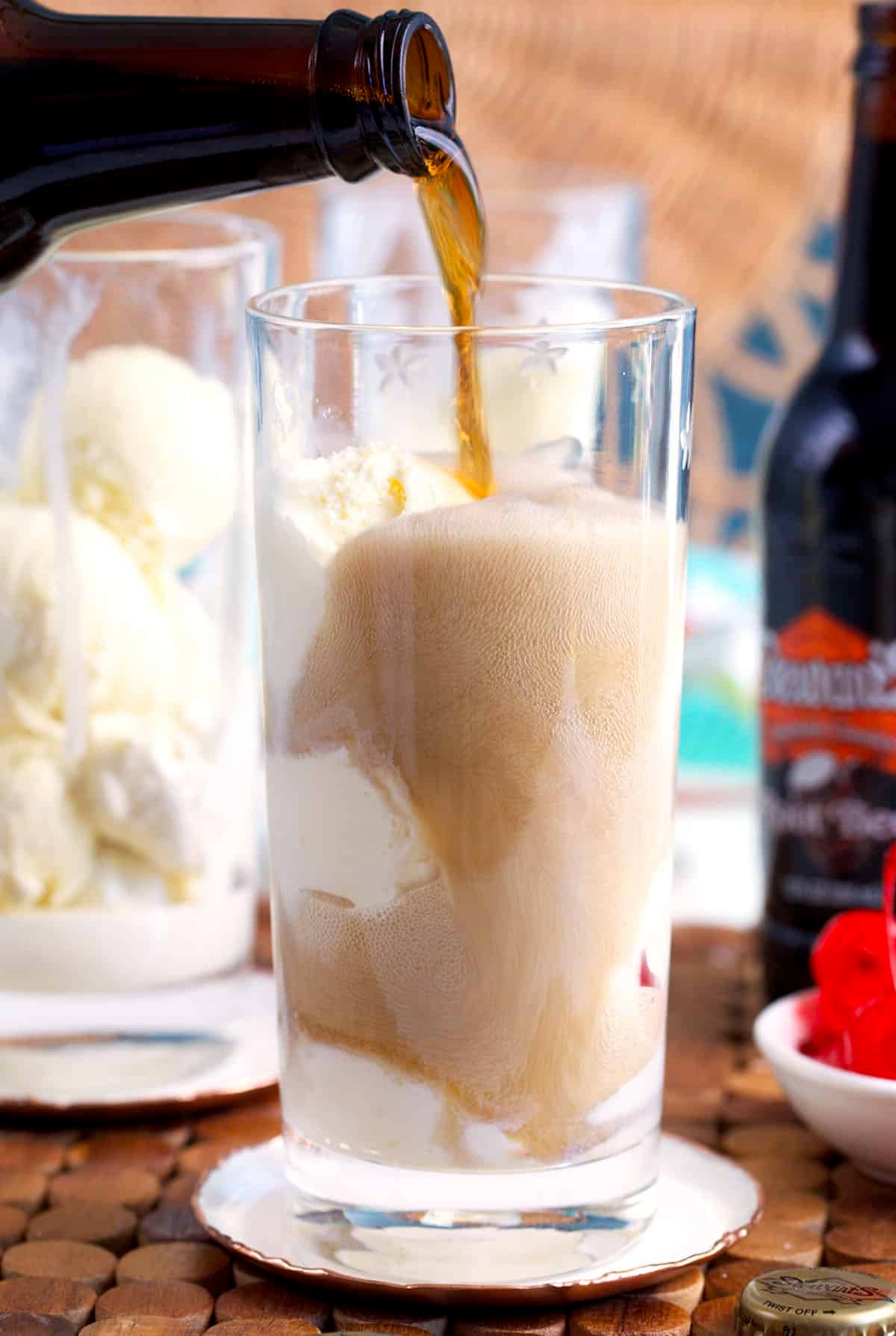 root beer being poured into a glass with vanilla ice cream