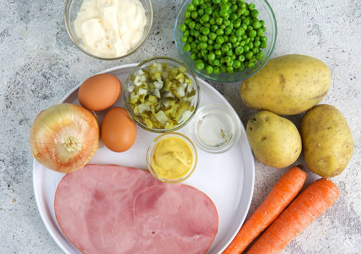 Ingredients for Russian Salad ham steak, potatoes, carrot, peas, pickles, eggs, mayo and dressing ingredients