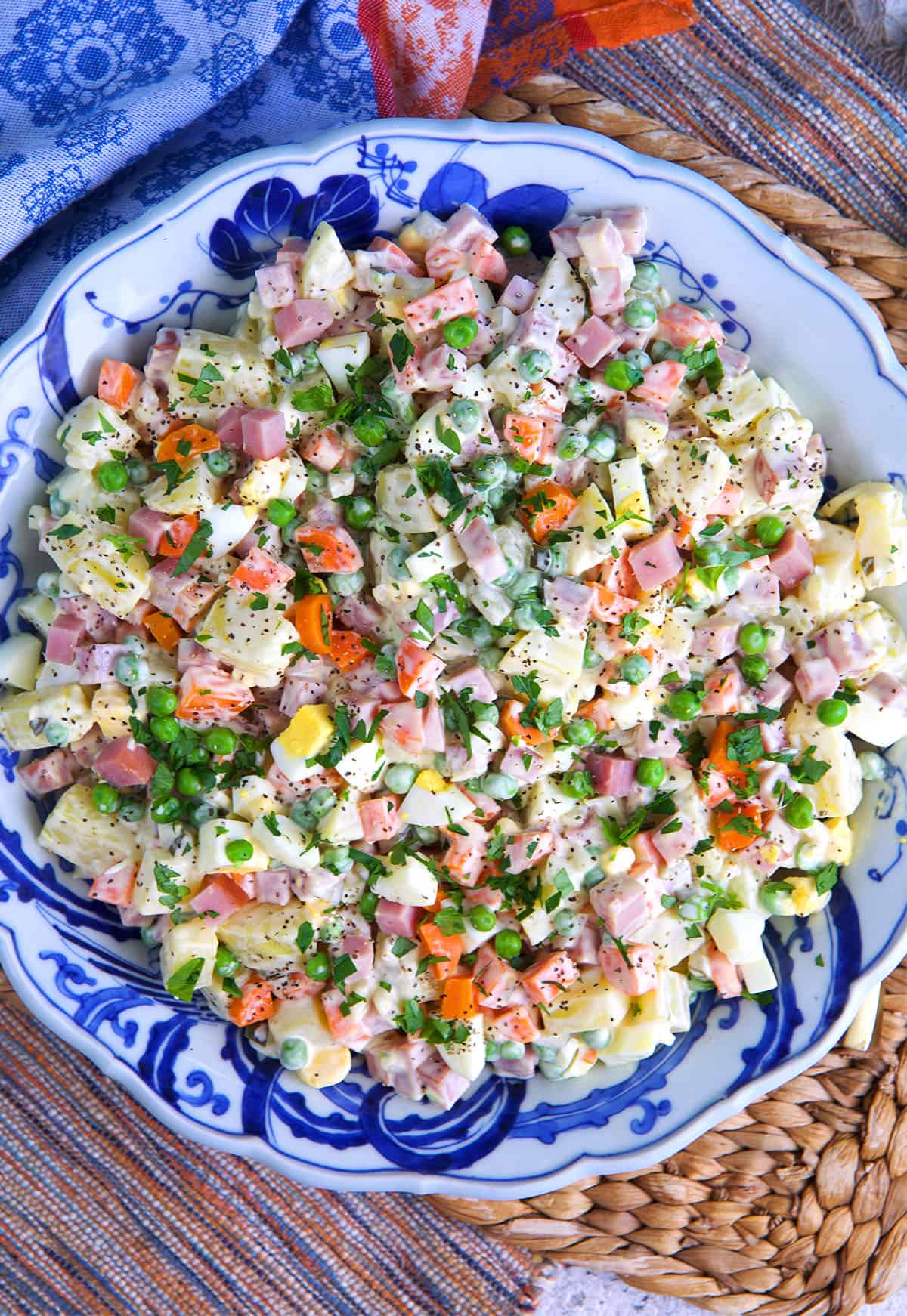 Russian potato salad in a blue and white bowl