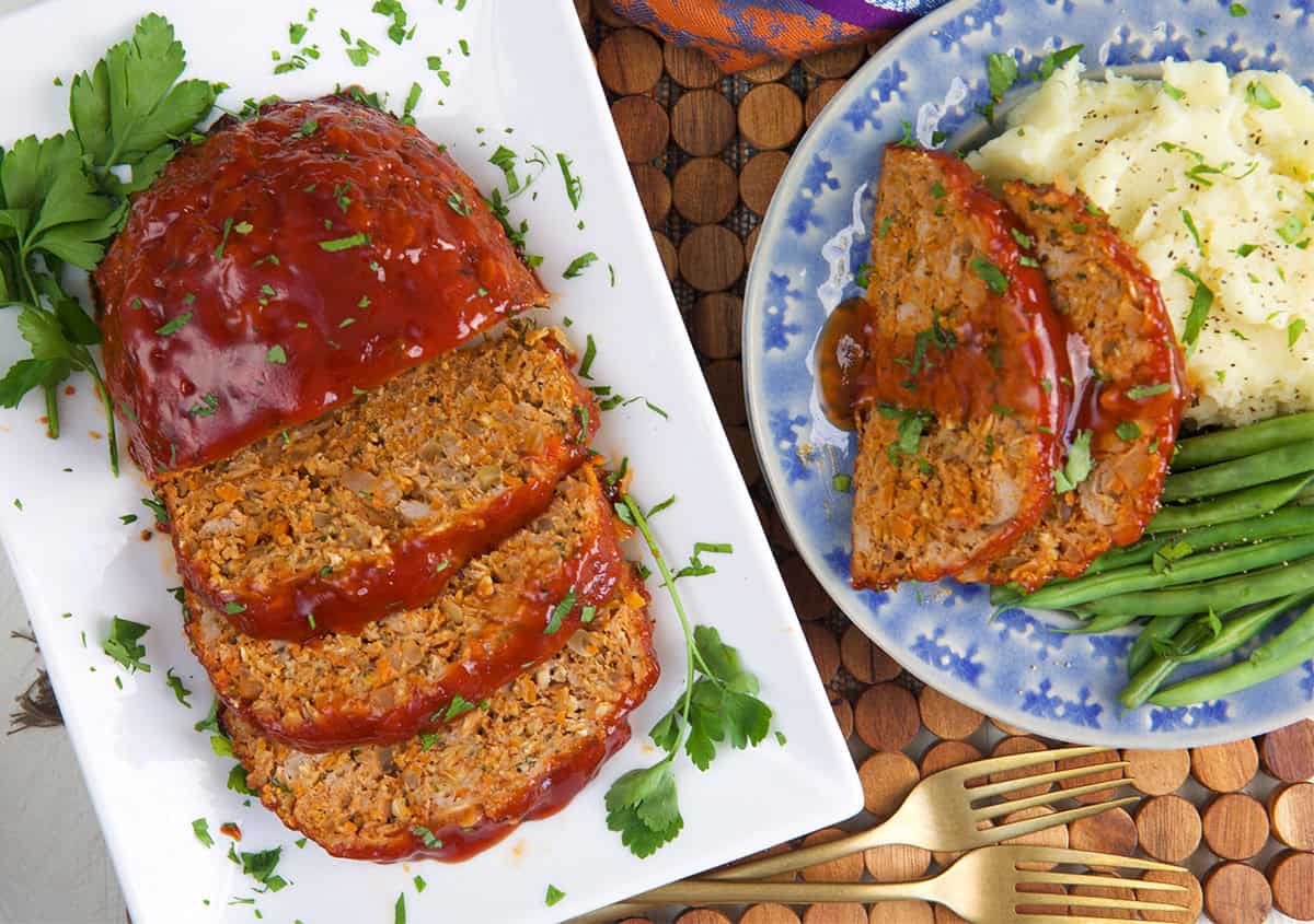 turkey meatloaf ready to be served with a plated meatloaf dinner with mashed potatoes and green beans.