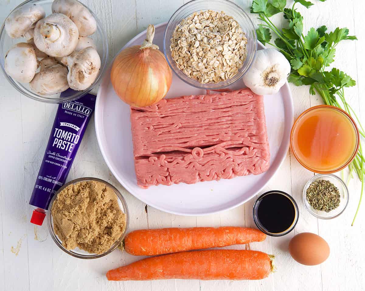 Ingredients for turkey meatloaf, ground turkey, onion, garlic, oats, carrots, mushrooms, tomato paste, seasoning