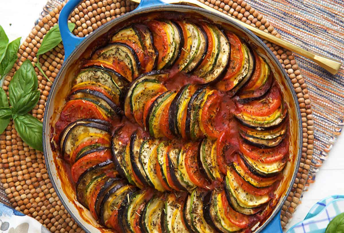 finished ratatouille in a baking dish with a gold serving spoon