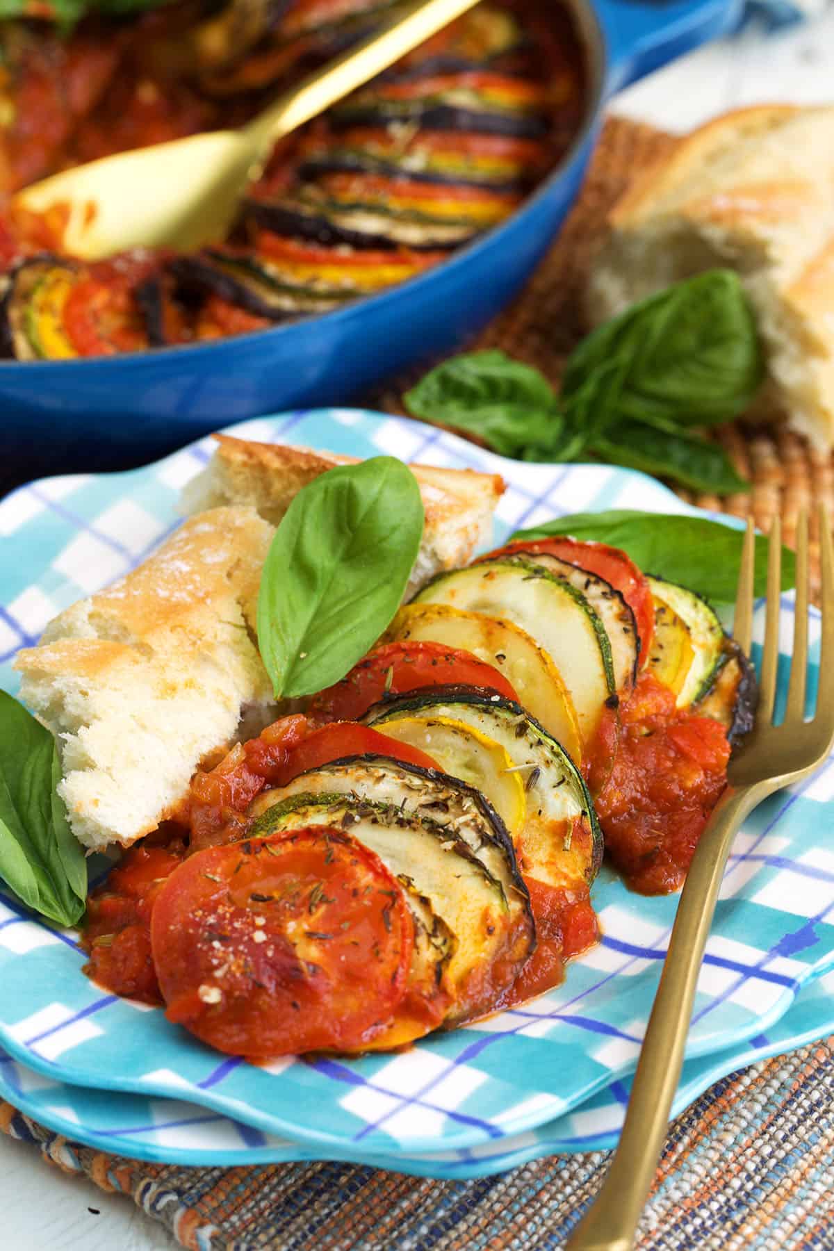 ratatouille served on a plaid plate with crusty bread