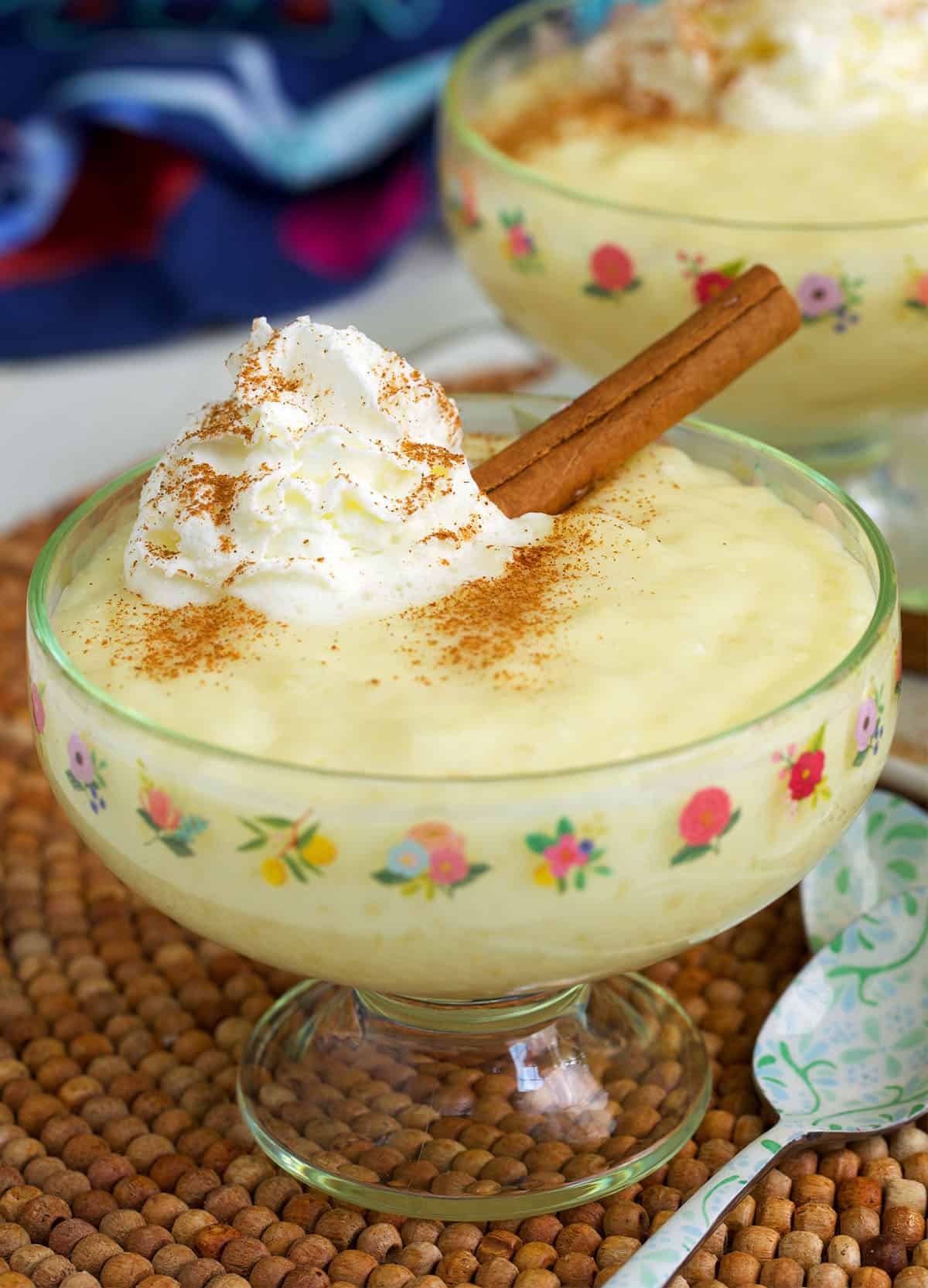 tapioca pudding recipe in a small dish with a cinnamon stick on top.
