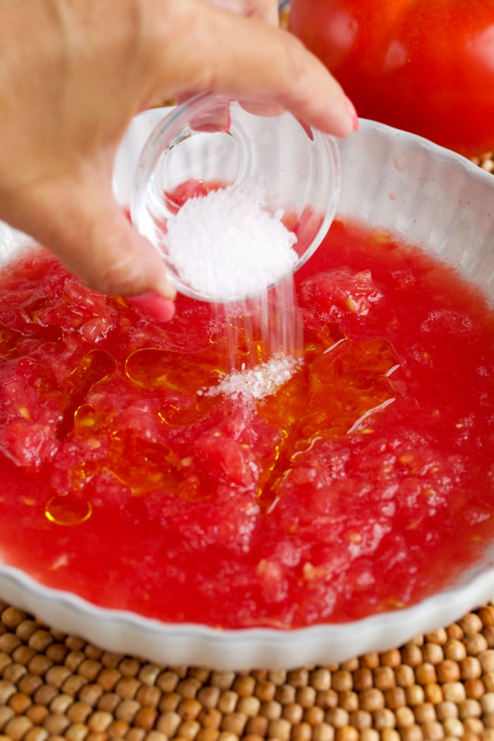 salt being added to grated tomato