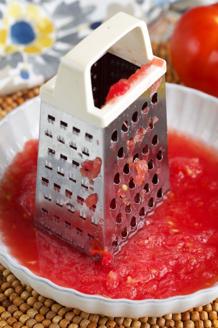 box grater with grated tomato in a bowl