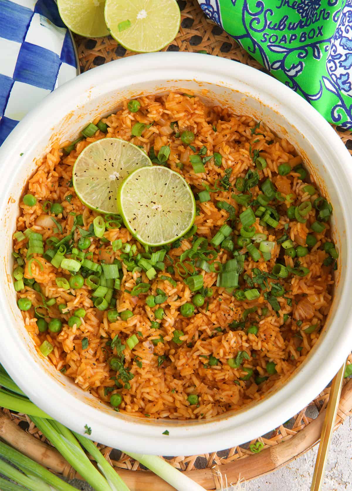 mexican rice in a pot ready to be served with chopped green onion and lime.