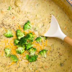 Broccoli Potato Soup in a blue dutch oven with a white silicone ladle.