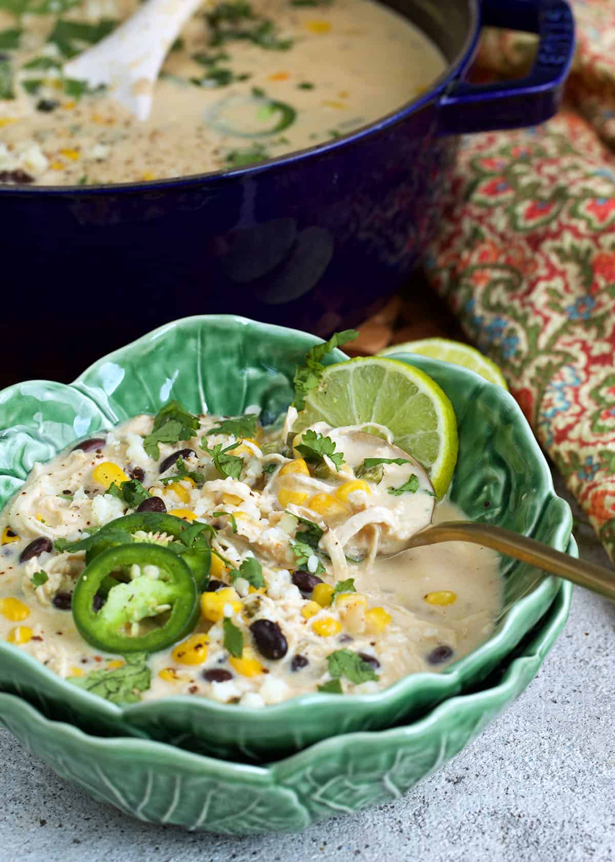 Chicken poblano soup in a cabbage bowl with a gold spoon.