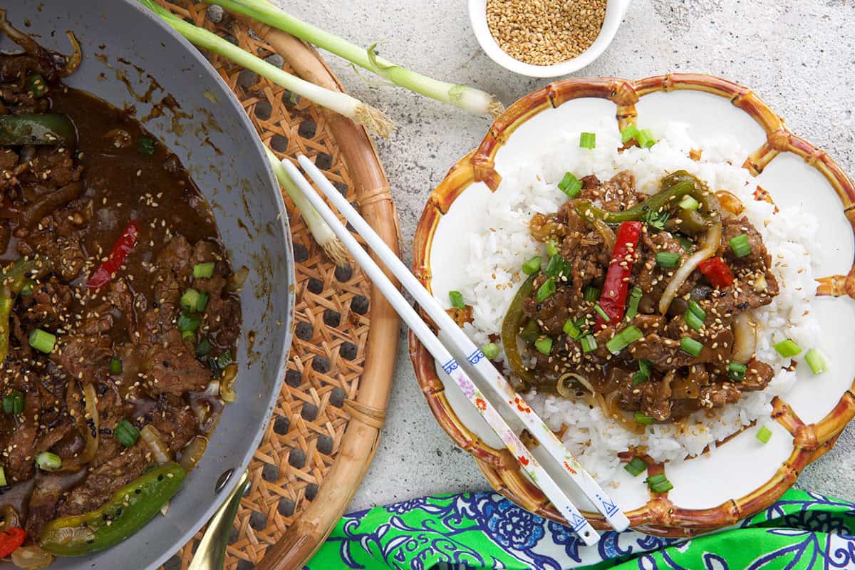 Homemade pepper steak recipe with tender sliced beef, red and green bell peppers, and savory sauce served over white rice.